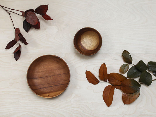 Fall foliage on table with empty wooden dishes