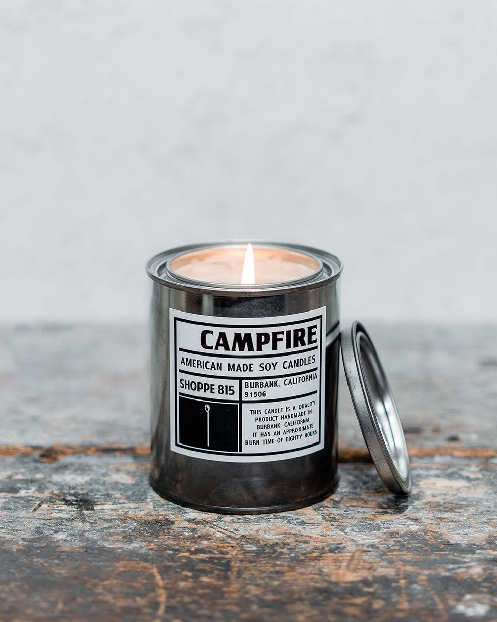 Lit Campfire tin can candle on wooden counter