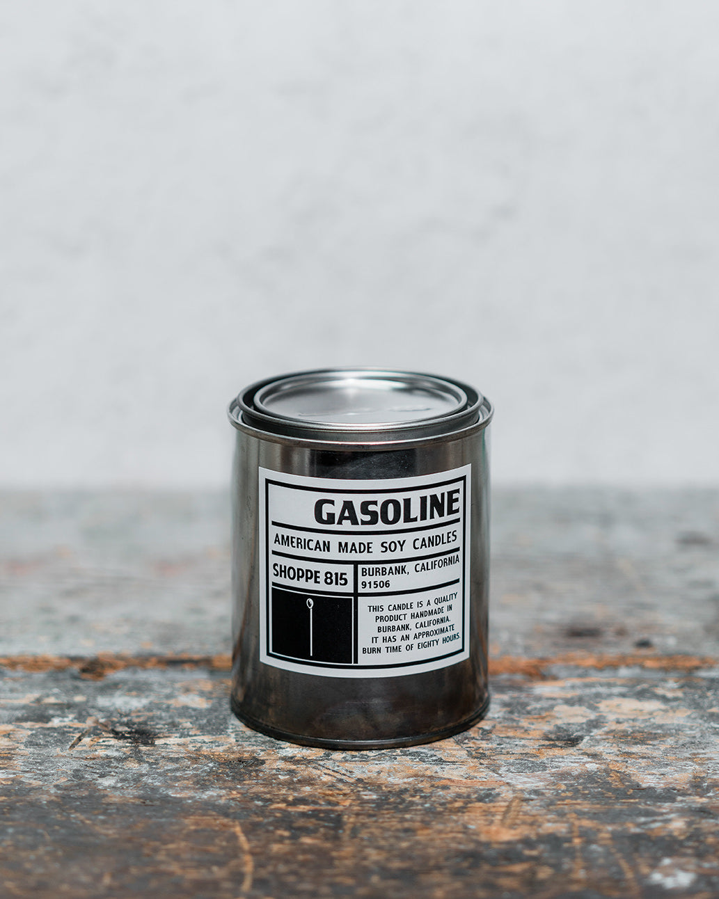 Gasoline gender neutral tin candle on wooden shelf with packaging