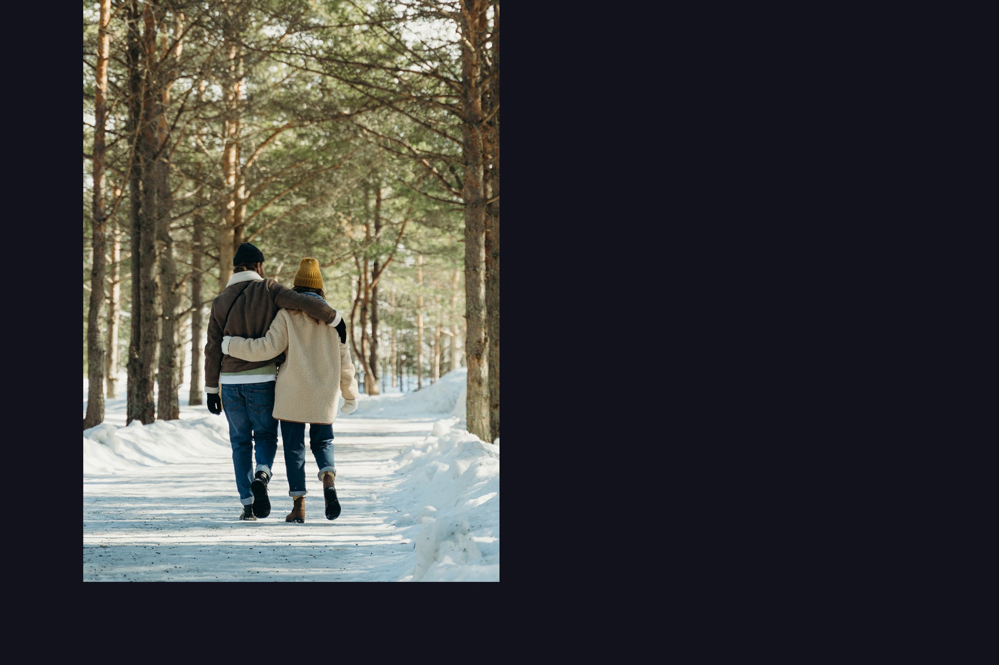 A couple walking on a snow covered path on a winter day, enjoying the smell of spruce trees.  A simple moment that will ignite memories for years to come! 