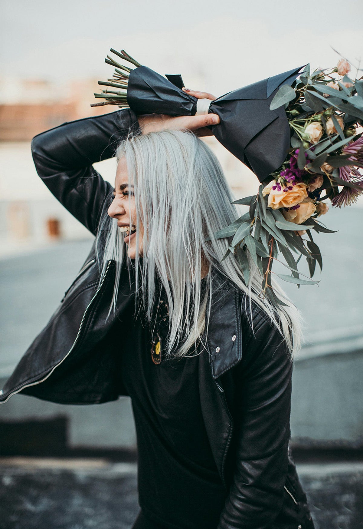 A girl treating herself to a boutique of flowers with a smile on her face.  Enjoying the scent of a fresh start she'll appreciate in the days to come.