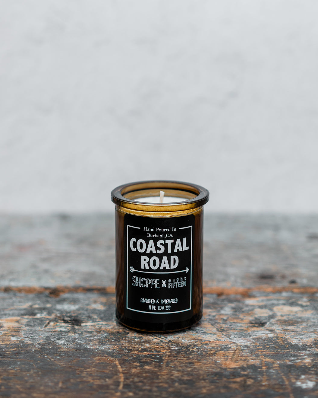 Coastal Road amber glass candle on wooden shelf