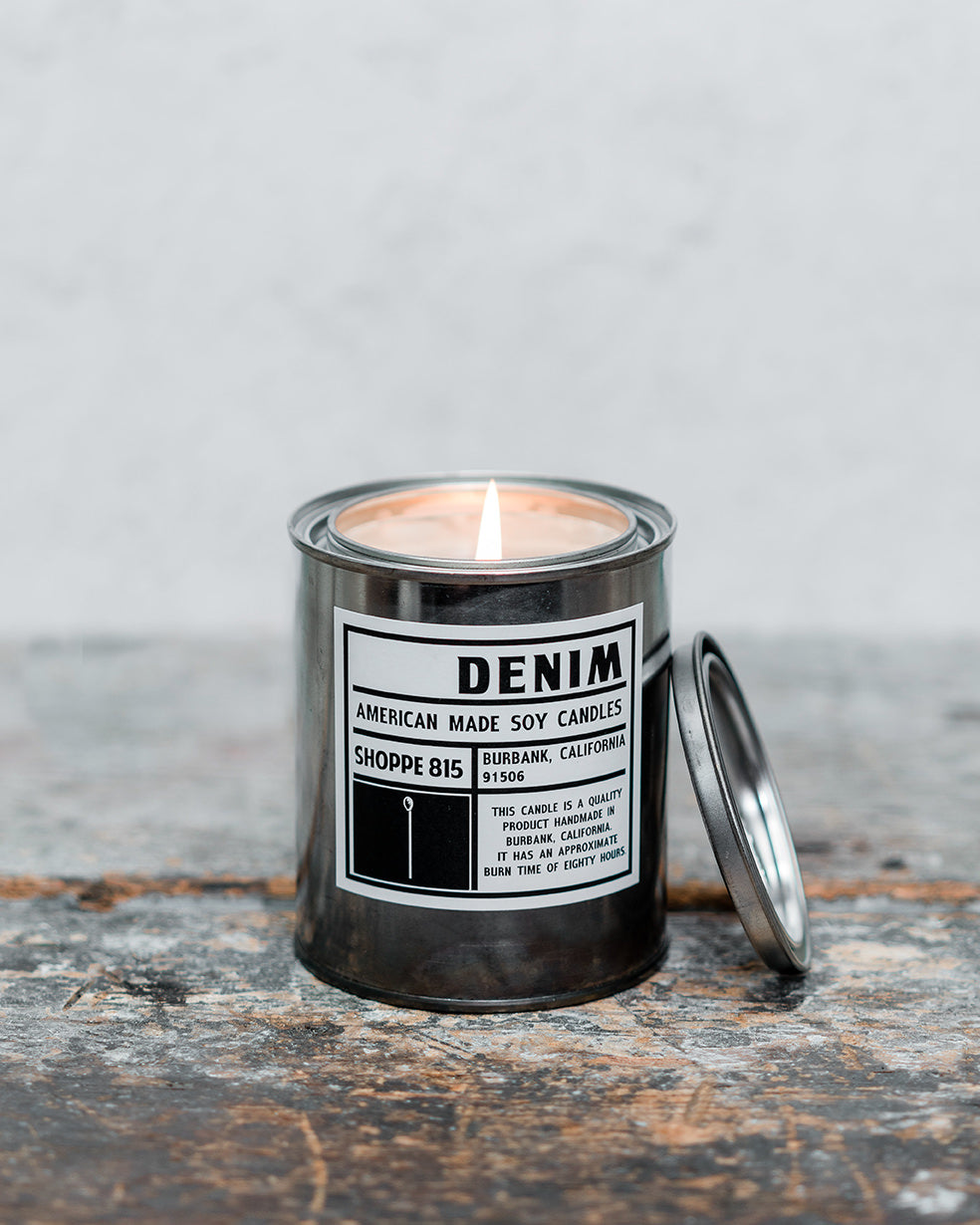 Lit Denim gender neutral tin candle on wooden shelf