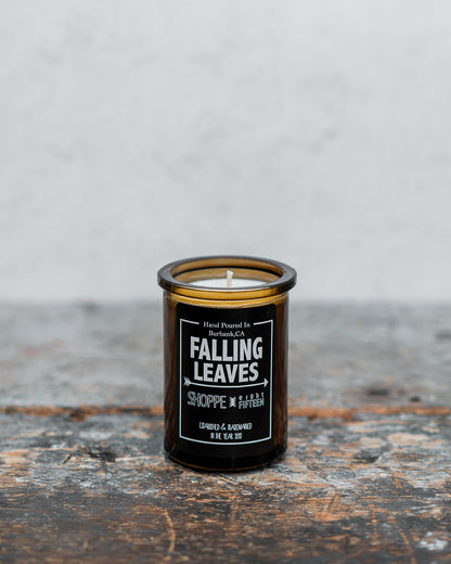 Falling Leaves amber glass candle on wooden shelf