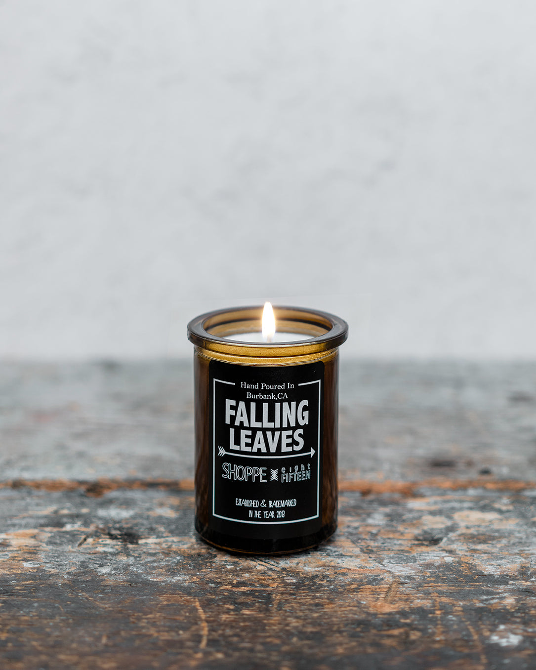 Falling Leaves amber glass candle on wooden shelf