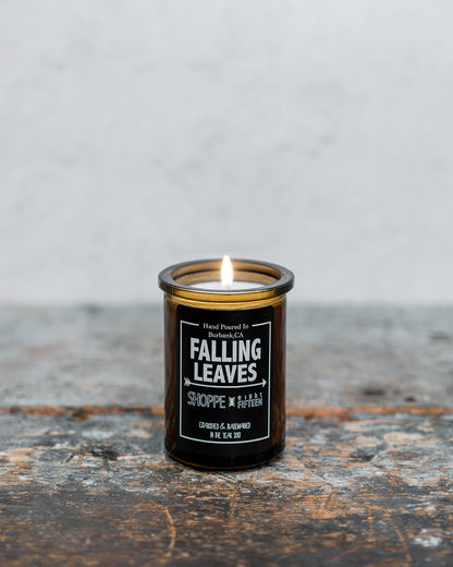 Falling Leaves amber glass candle on wooden shelf