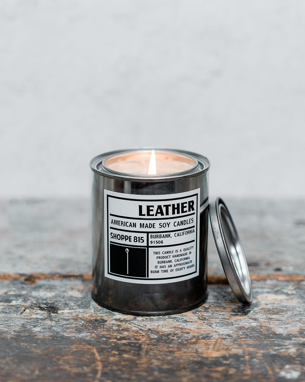 Lit Leather unisex tin candle on wooden shelf