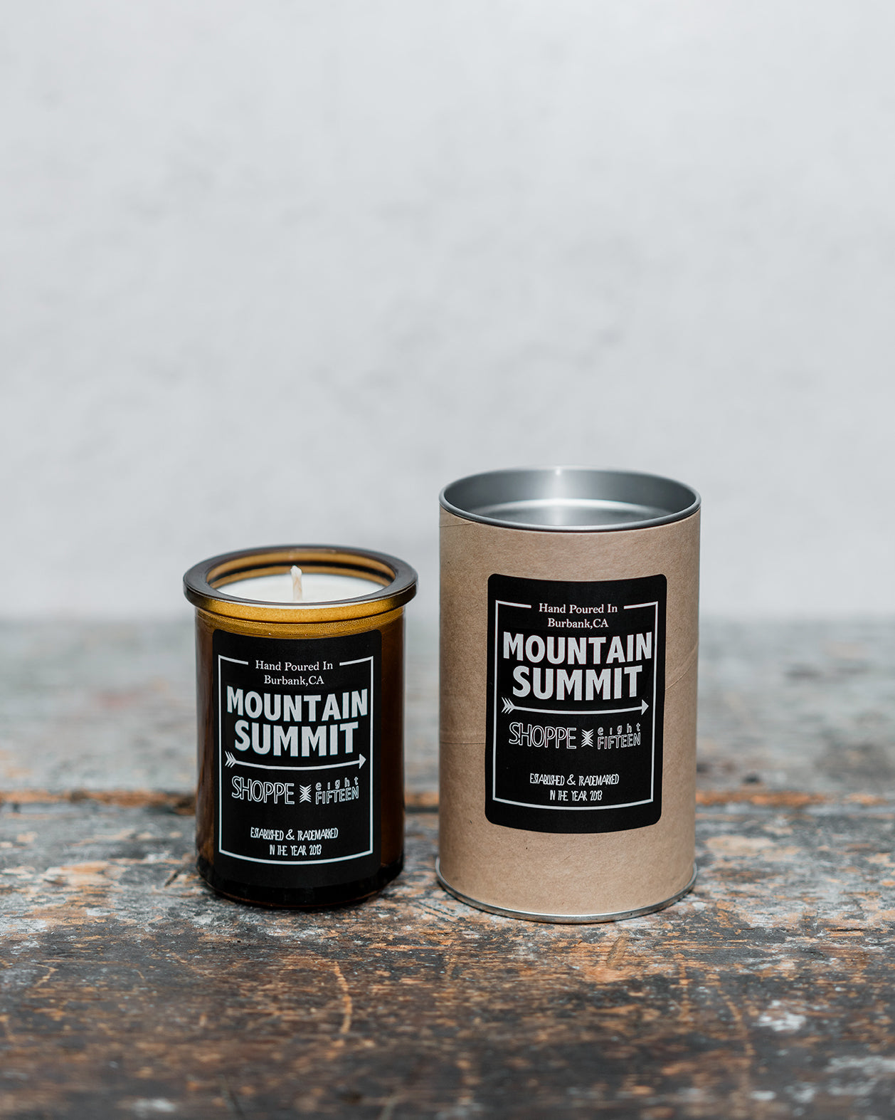Mountain Summit amber glass candle on wooden shelf with packaging